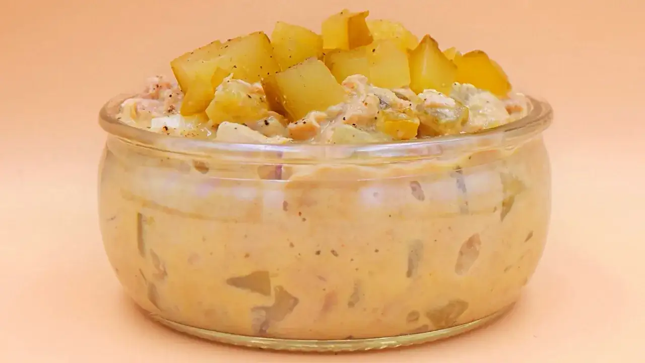 Pyszna pasta z tuńczyka z ziemniakami i ogórkiem kiszonym w słoiczku, posypana kostkami ziemniaków.