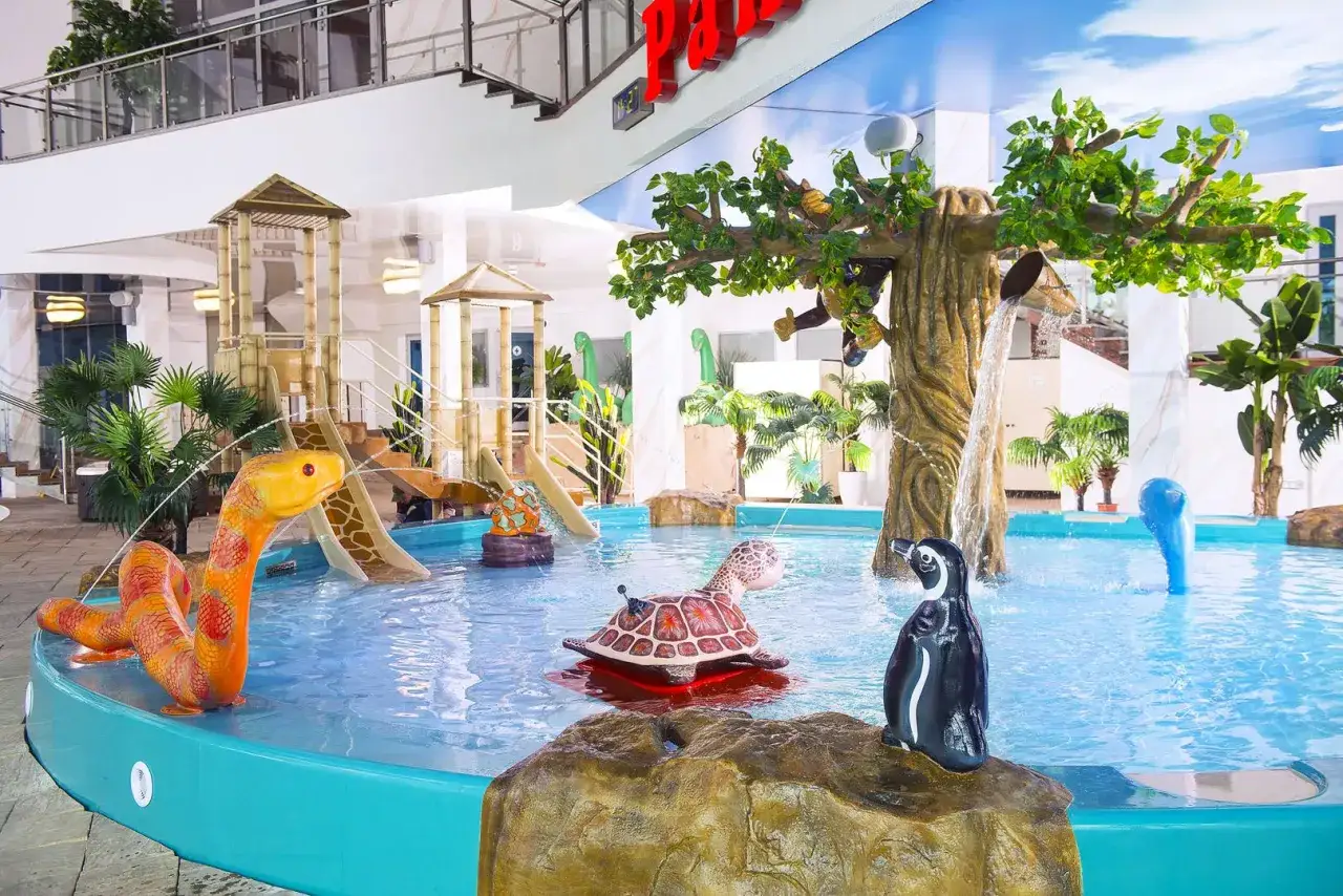 Wesoły hotel z parkiem wodnym dla dzieci: zjeżdżalnie, żółw, pingwin i wąż wodny zachęcają do zabawy.