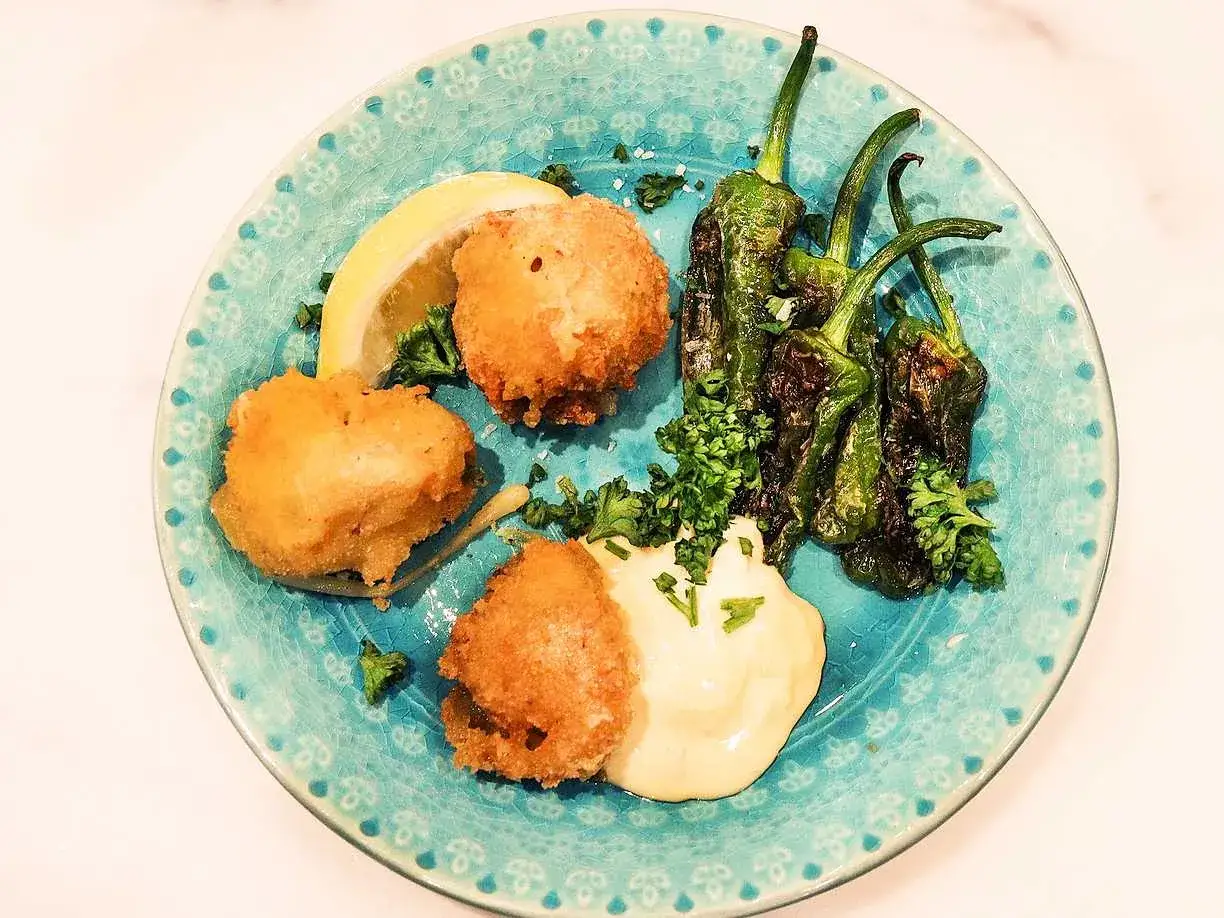 Krispiga kroketter med en krämig dipp, serverade med friterade padrones och citronklyfta. Ett perfekt kroketter recept för en tapasbuffé.