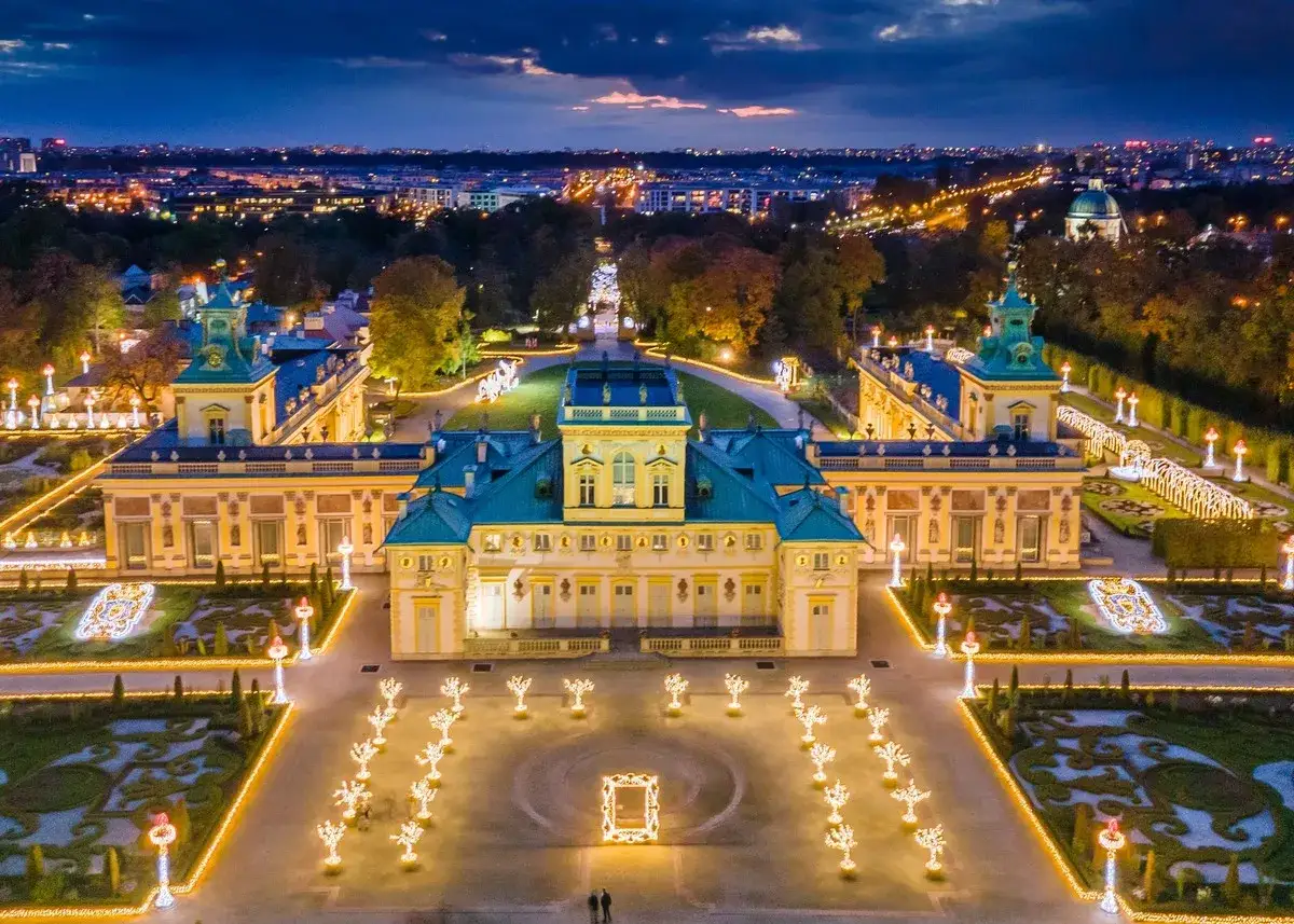 Pałac w Wilanowie nocą, oświetlony tysiącami świateł, przypomina bajkową scenerię. To miejsce, które mogłoby być sercem najbogatszej dzielnicy Warszawy, emanując przepychem i historią.