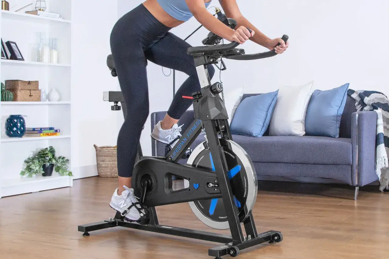 Woman cycling on a stationary bike, demonstrating how magnetic resistance works by adjusting the magnetic field to control pedaling effort.