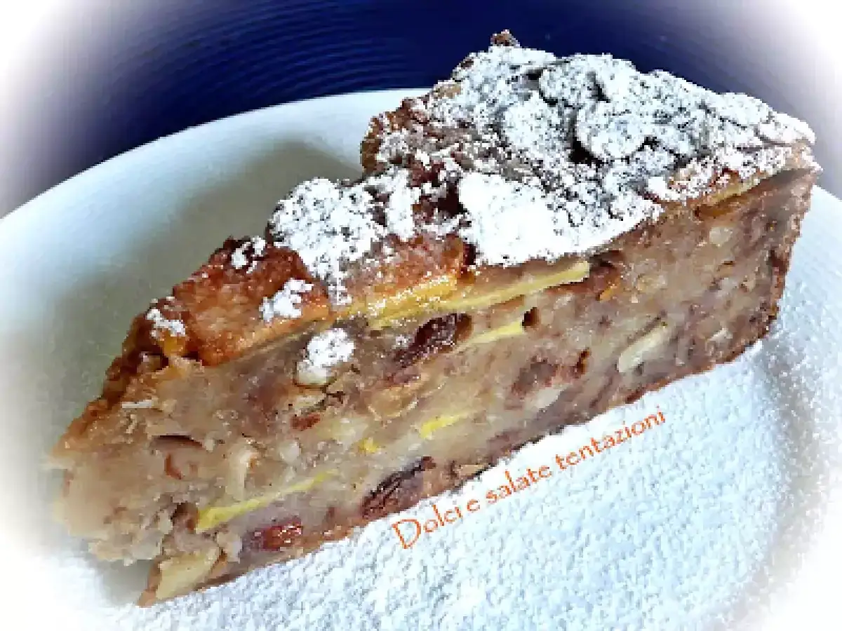 Una fetta di pincia veneziana, dolce tradizionale con frutta secca e mele, cosparsa di zucchero a velo.