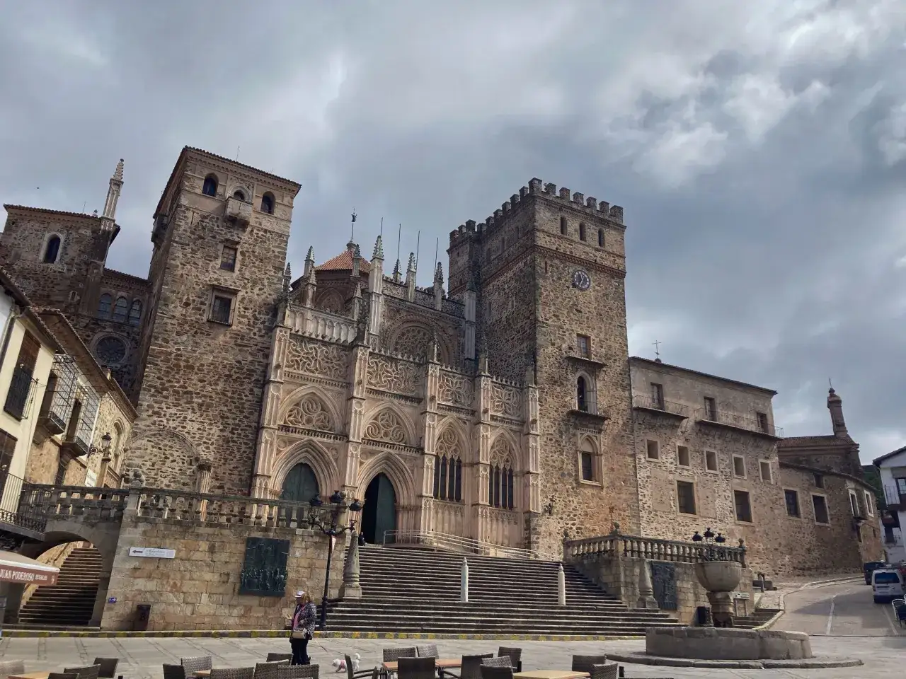 Impresionante fachada de piedra de la Catedral de Santa María de Guadalupe en España, con su torre y escalinata.