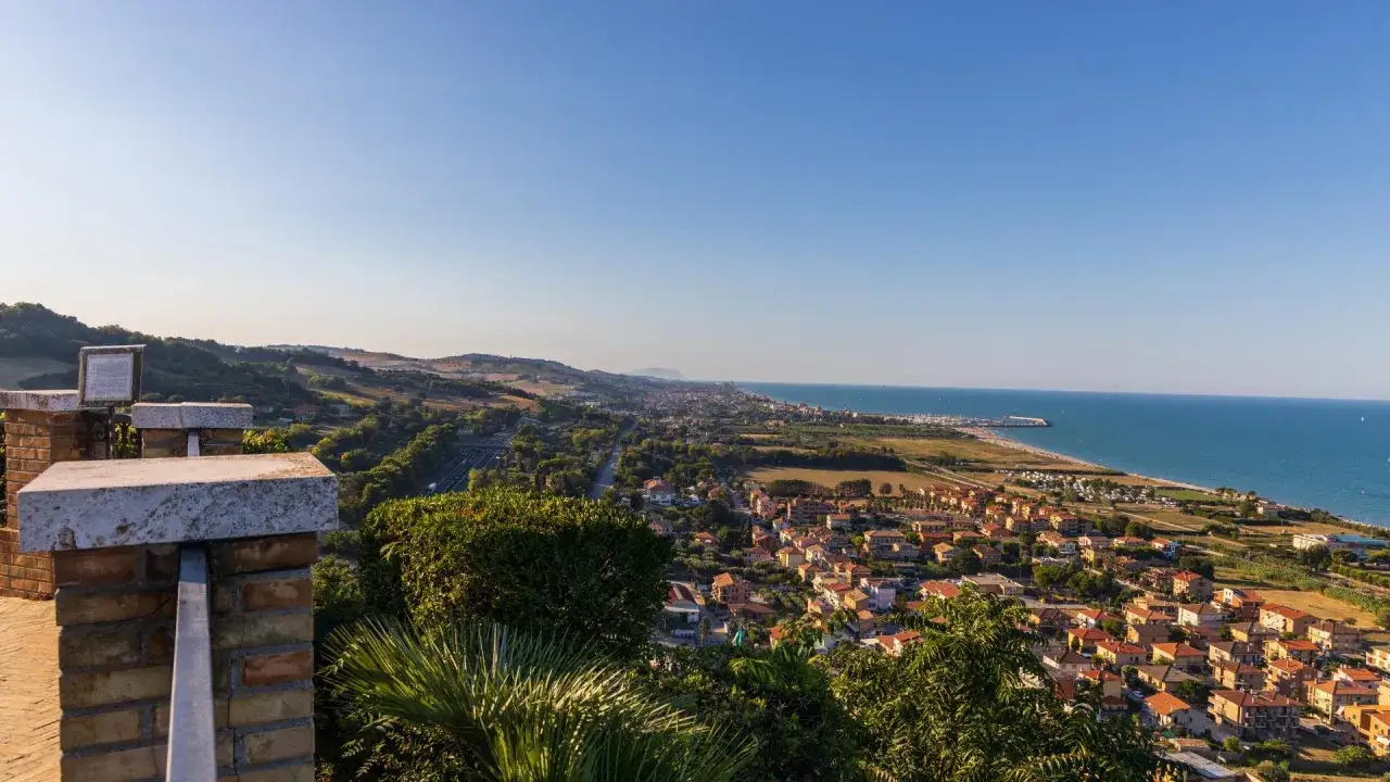 Vista panoramica di Marina Palmense con la sua spiaggia dorata, il mare azzurro e le case dai tetti rossi.