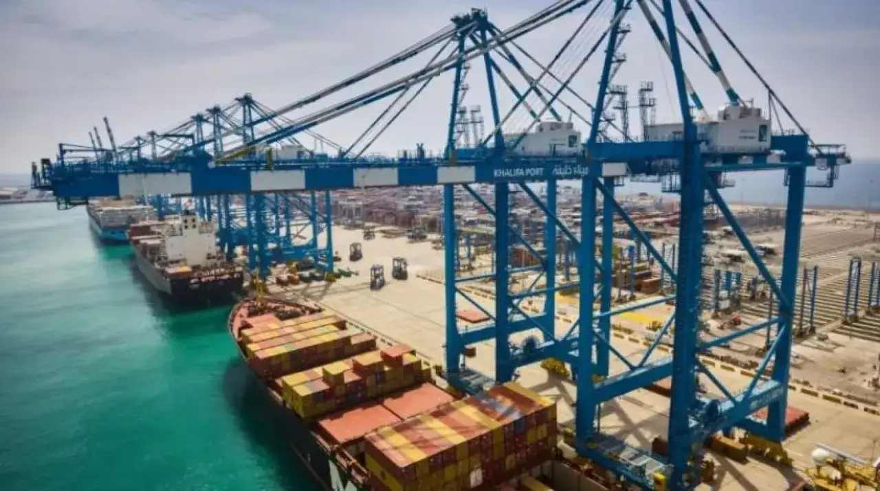 Große blaue Kräne beladen Containerschiffe im Hafen von Port Sudan.