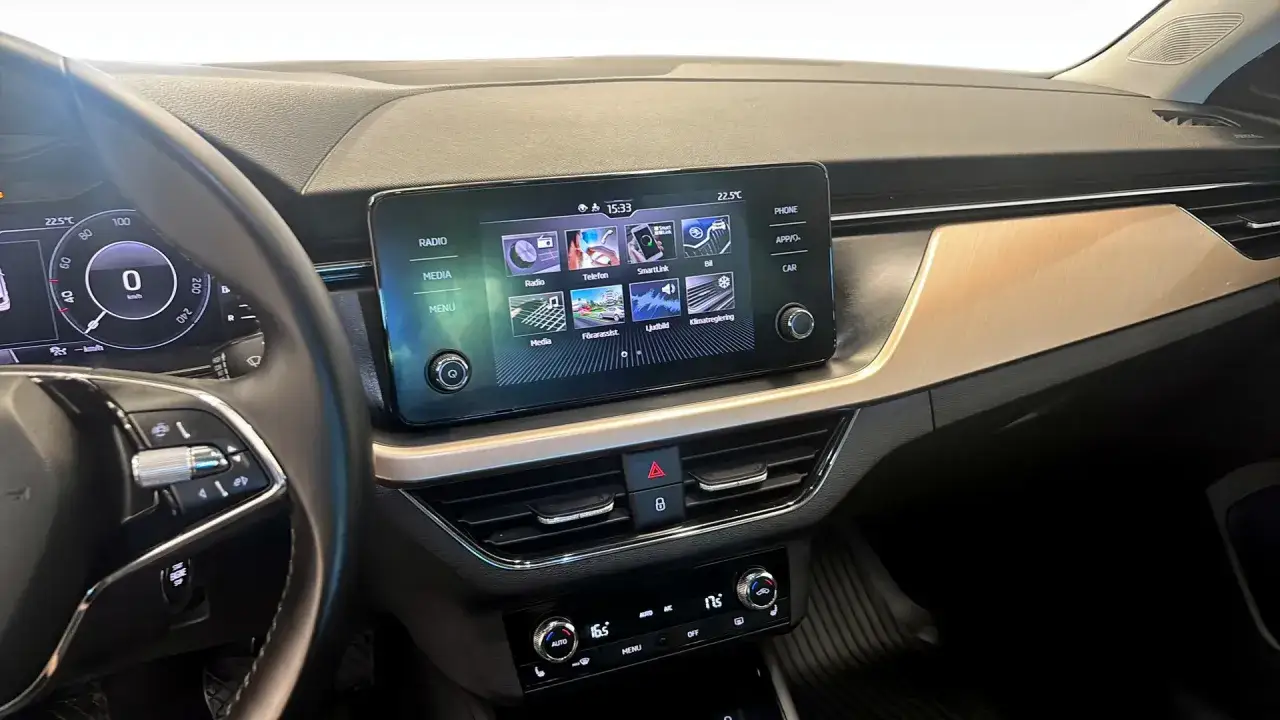 Skoda Kamiq-infotainmentsystem med radio, media och klimatkontroller. En digital hastighetsm&auml;tare syns till v&auml;nster.
