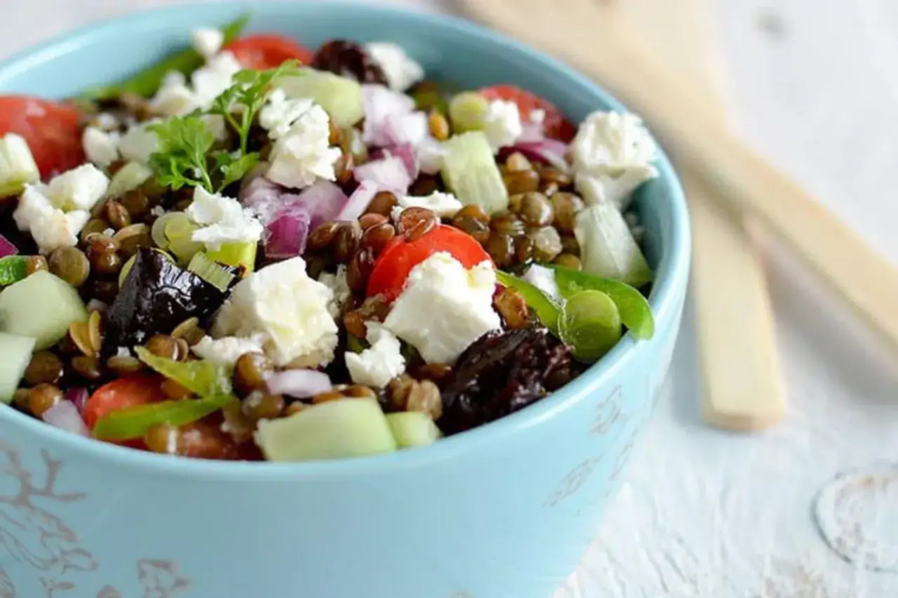Salade de lentilles, feta, tomates, concombre et oignons rouges, garnie de persil frais. Un délice sain et coloré.