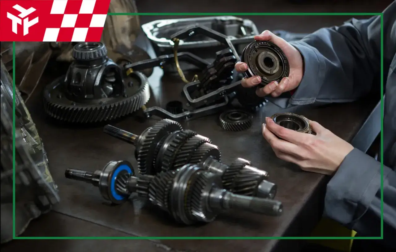 Mechanik składa elementy skrzyni biegów, kluczowy element układu napędowego samochodu.