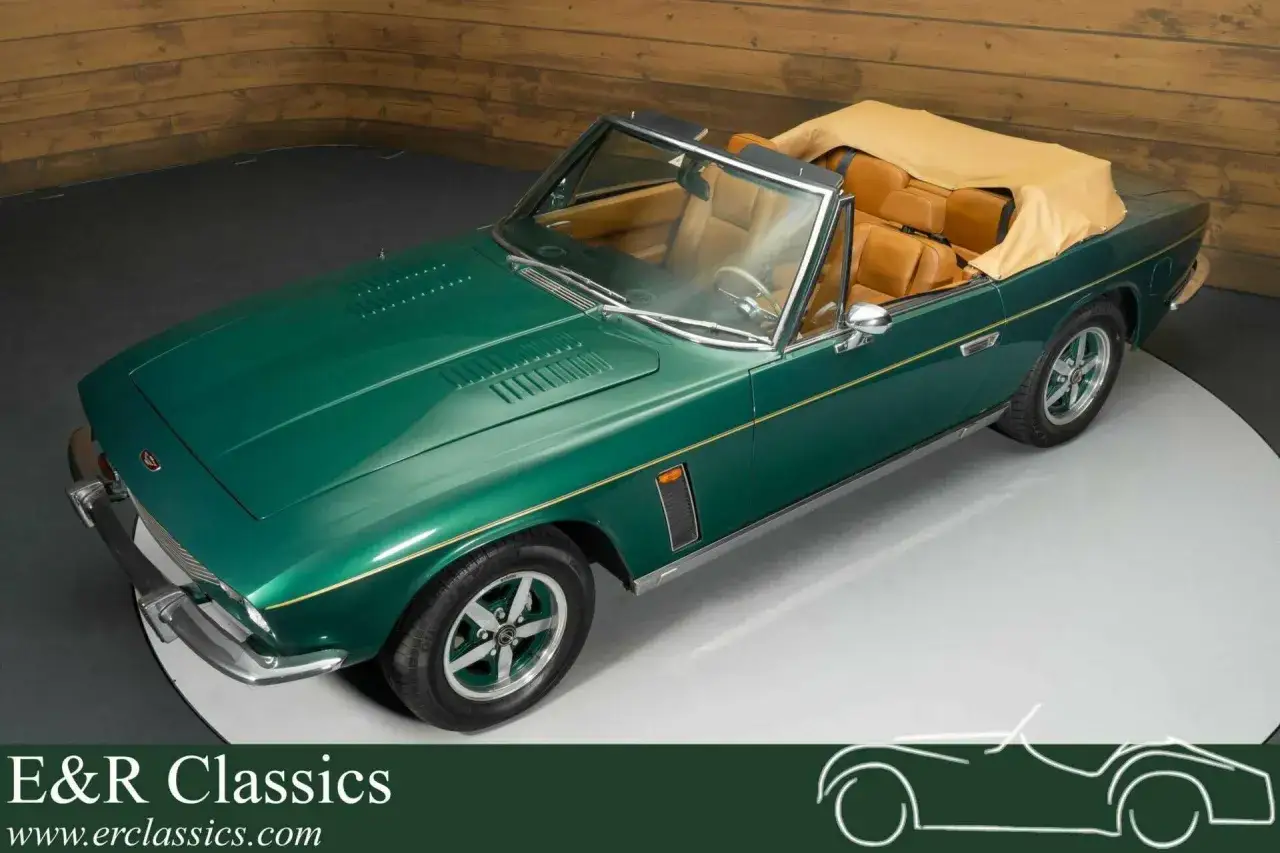 Grüner Jensen Interceptor Auto mit offenem Verdeck und brauner Lederausstattung, bereit für eine Spritztour.