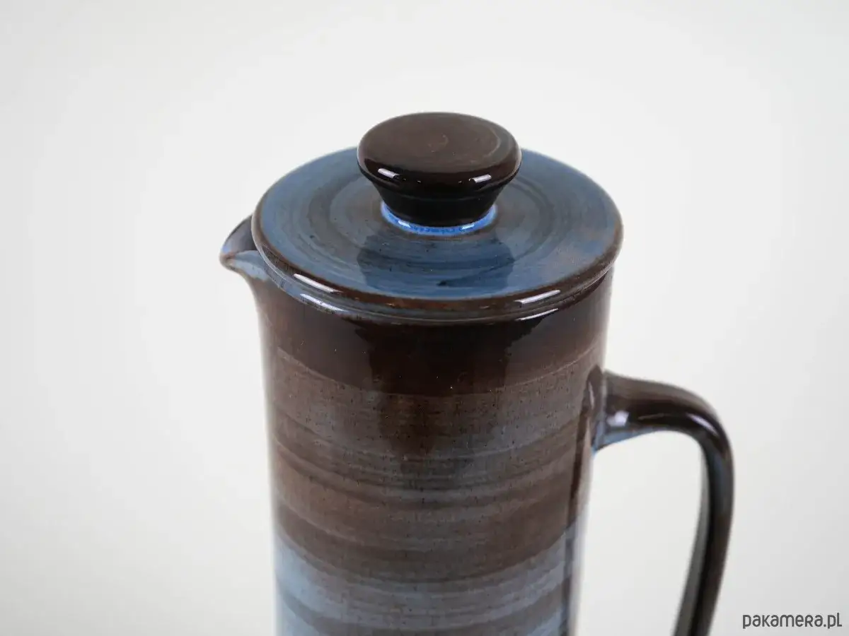 Ceramiczny dzbanek z niebieską pokrywką. Idealny pomysł na to, co przywieźć z Danii &ndash; stylowy i praktyczny.