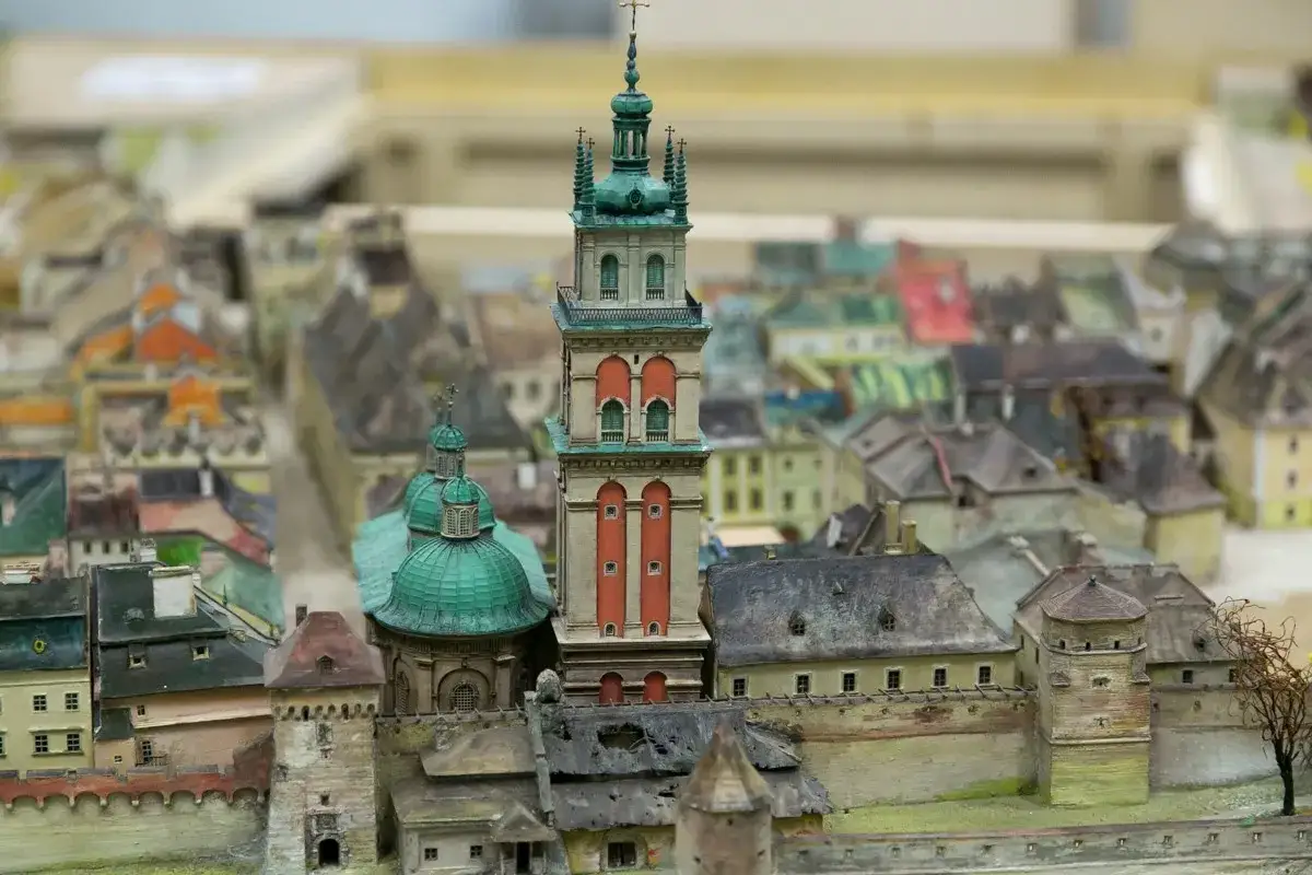 Miniatura Lwowa z wieżą i kopułami. Widać gęstą zabudowę, sugerującą dużą liczbę mieszkańców.