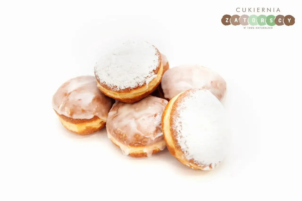 Stos pączków, niektóre oblane lukrem, inne posypane cukrem pudrem. Pyszna pokusa, choć warto pamiętać o pączek kcal.