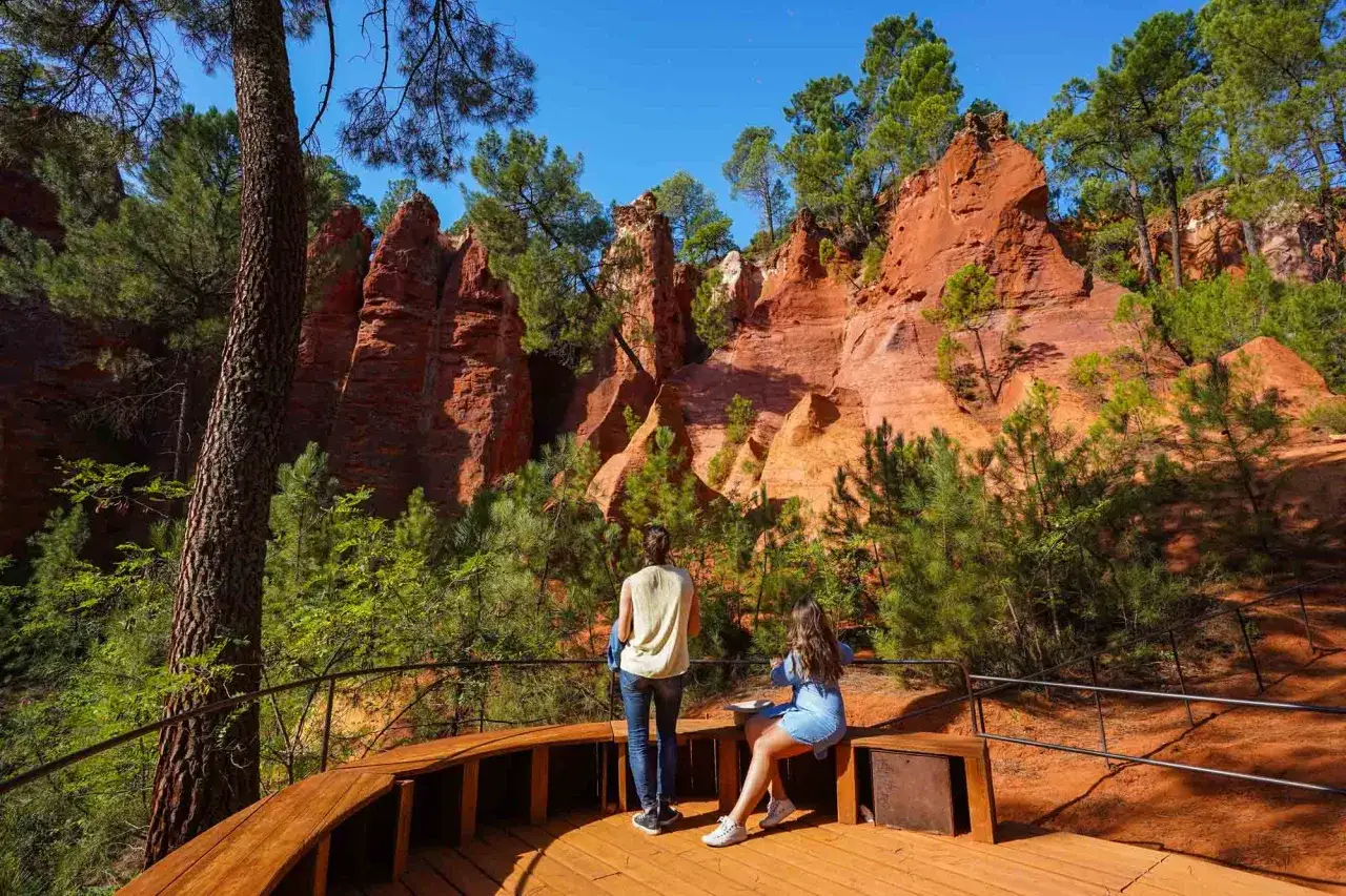 Deux femmes contemplent les falaises ocres des chemin&eacute;es de f&eacute;e roussillon, un paysage spectaculaire de Provence.
