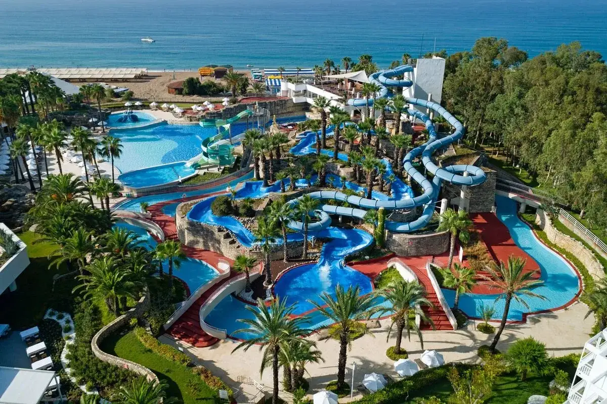 Wodne szaleństwo w Monachus Family Resort Sorgun! Mn&oacute;stwo zjeżdżalni, basen&oacute;w i palm tworzy raj dla rodzin.