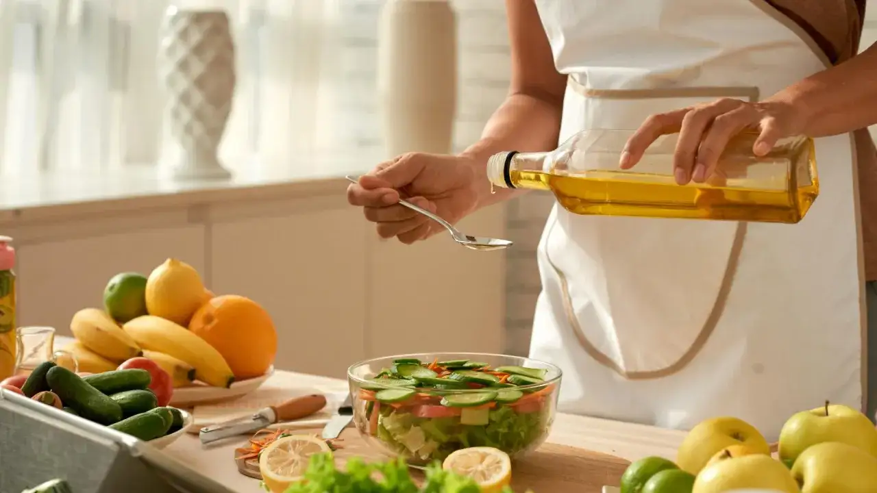 Persona a&ntilde;ade aceite de oliva a una ensalada, sin saber las desventajas del aceite de oliva.