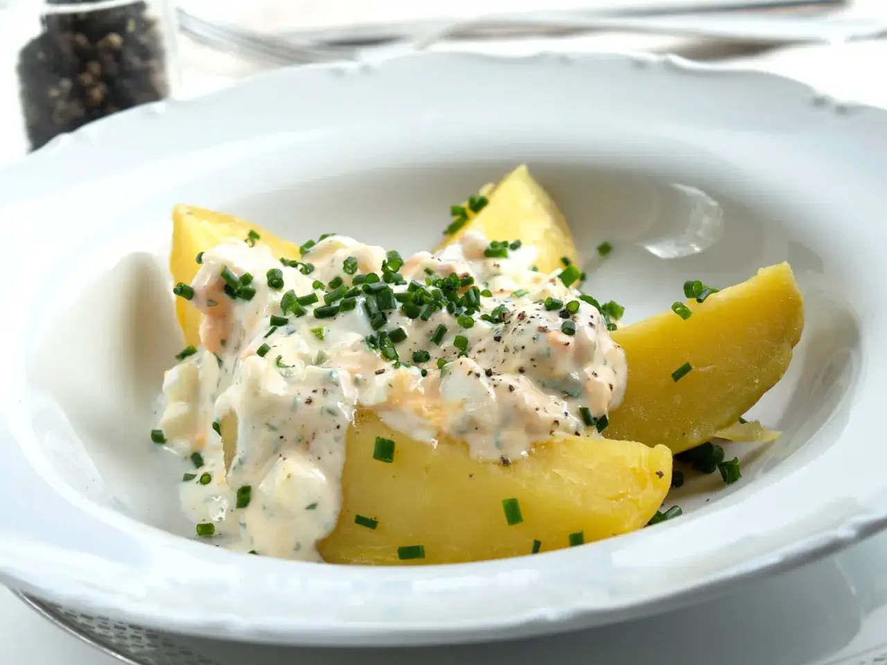 Ged&auml;mpfte Kartoffeln mit einer cremigen Quarkso&szlig;e, verfeinert mit Kr&auml;utern und Pfeffer. Ein Klassiker: Kartoffeln mit Quark.