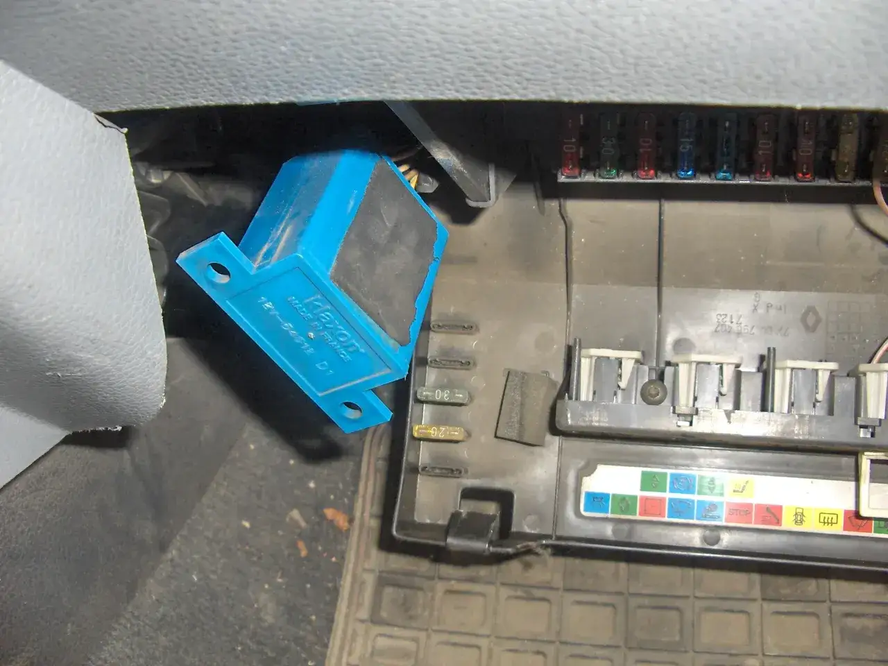 Wiązka przewodów i bezpieczniki w Renault Clio 3. Widoczny niebieski moduł i bezpiecznik świateł mijania.