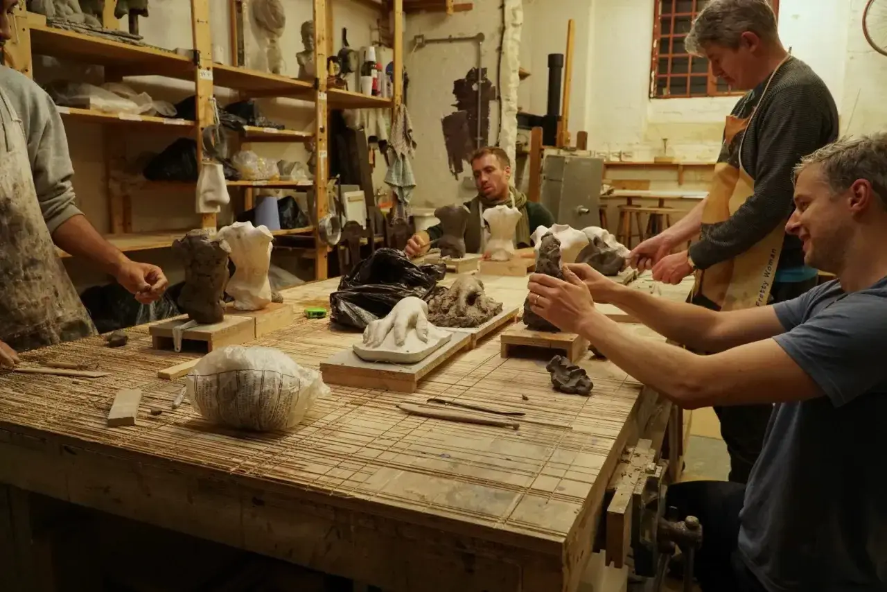 Students at a sculpture workshop, learning what are the best sculpture schools by hands-on practice.