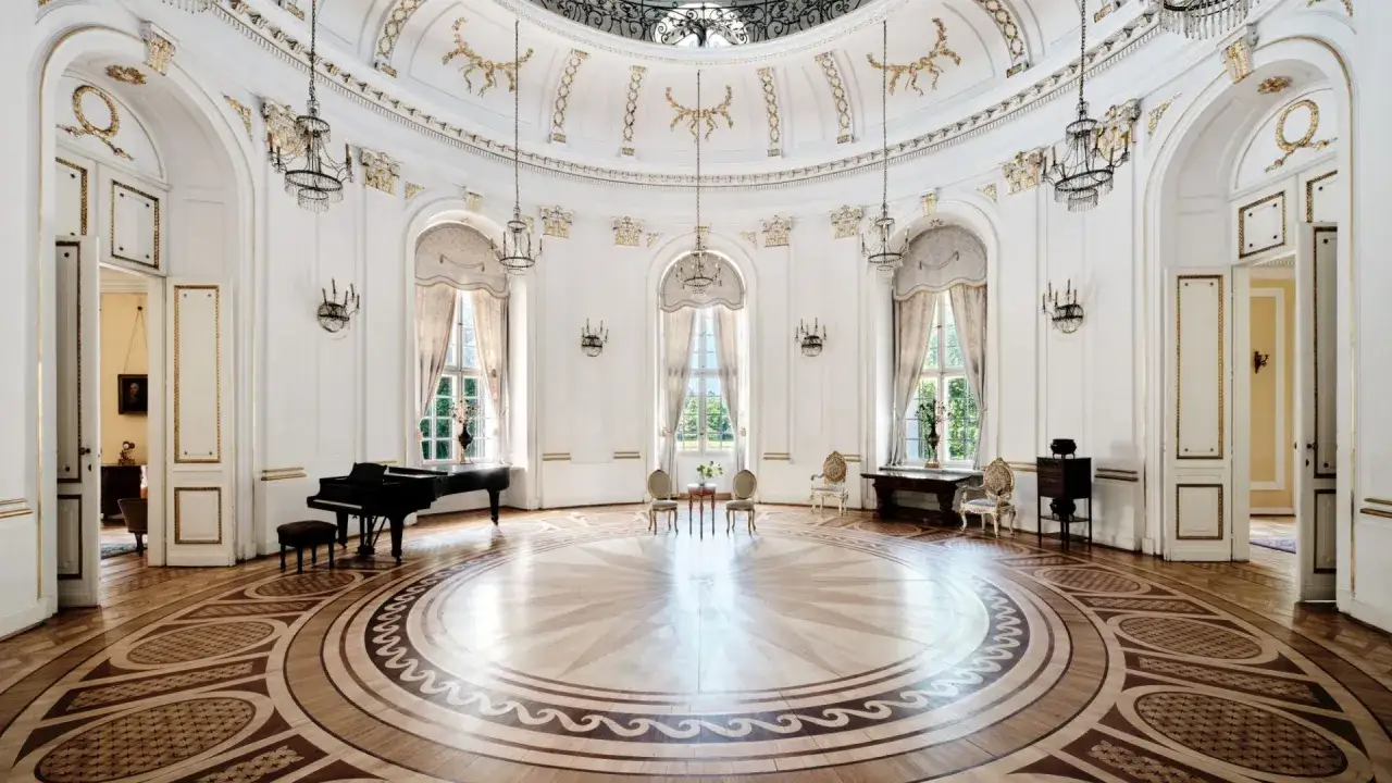 Elegancka sala balowa w Pałacu w Jabłonnie, z fortepianem i ozdobnym parkietem.