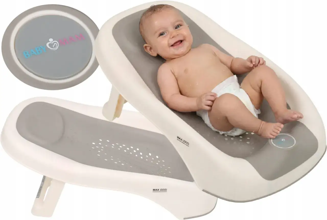 Uśmiechnięte dziecko w pieluszce leży w ergonomicznym krzesełku do kąpieli. Produkt BabyMam zapewnia bezpieczeństwo i komfort podczas higieny malucha.