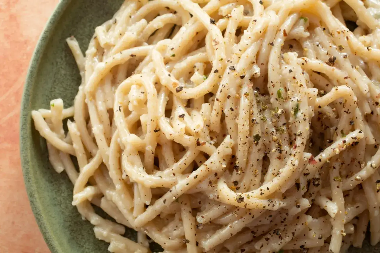 Cacio e pepe, ein einfaches, aber köstliches Pastagericht mit Käse und Pfeffer, serviert in einer grünen Schüssel.