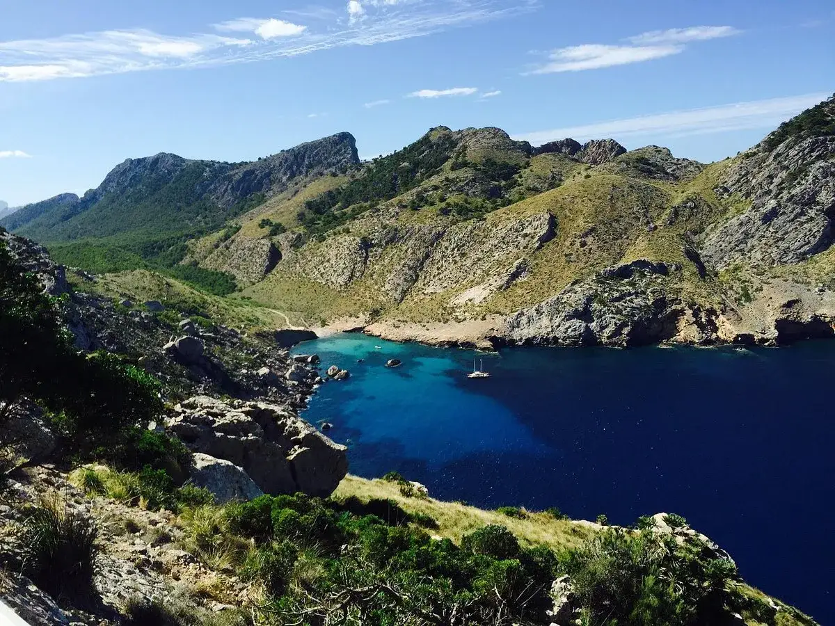 Vacker vy &ouml;ver en vik med turkost vatten och berg. Perfekt f&ouml;r att vandra p&aring; Mallorca och njuta av naturen.