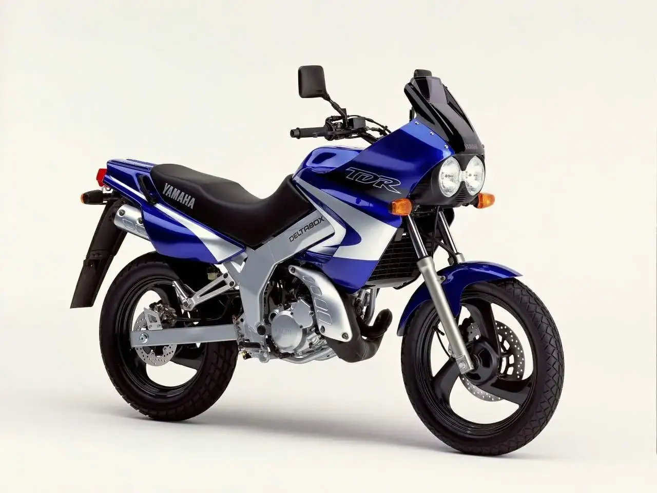 Niebieski motocykl Yamaha TDR z owiewką i podwójnymi światłami.