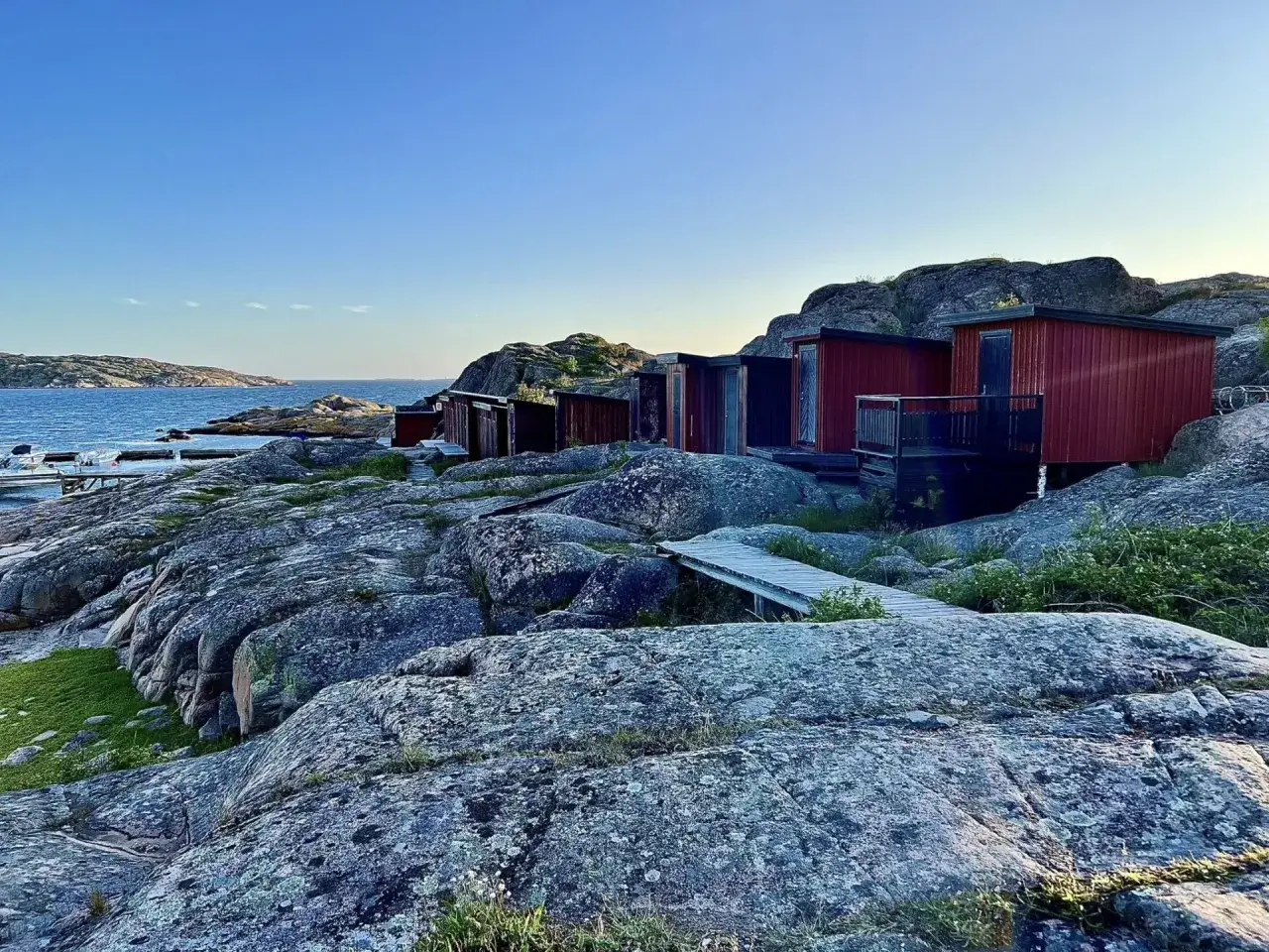 R&ouml;da stugor p&aring; klippor vid havet, en idyllisk plats f&ouml;r camping i Lysekil.