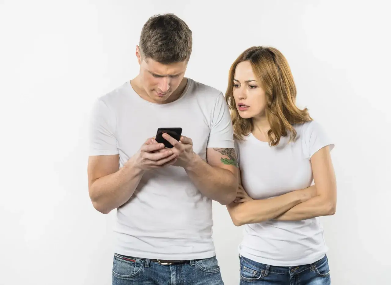 Para zaniepokojona patrzy na telefon, który trzyma mężczyzna. Czyżby to był zespół Otella?