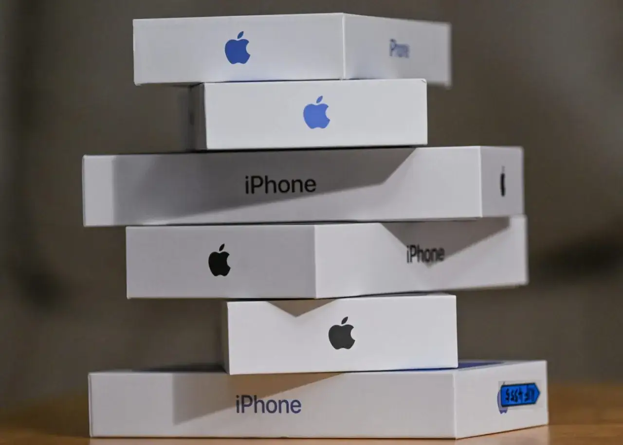Stos białych pudełek z logo Apple i napisem 