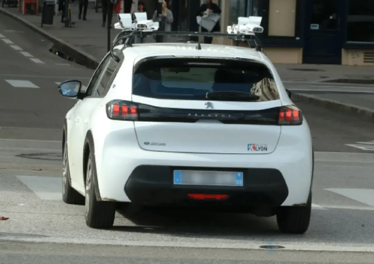 Voiture radar privé, équipée de capteurs sur le toit, en circulation.