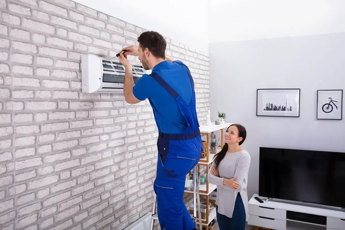 Tecnico installa climatizzatore, cliente osserva. Valuta il costo installazione climatizzatore per un ambiente fresco.