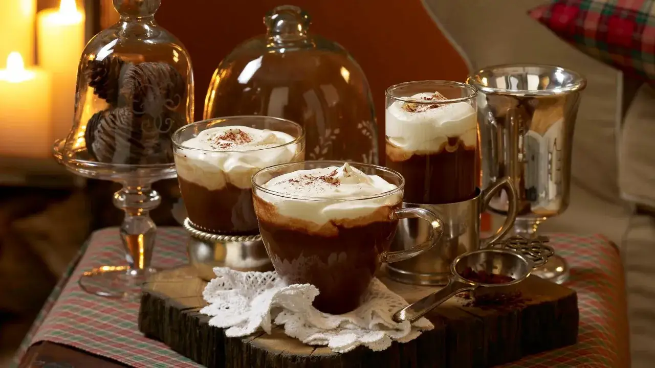 Gemütliche Tassen mit heißem Kakao und Sahne, verfeinert mit einem Hauch von Kaffee mit Baileys. Ein Genuss für kalte Tage.