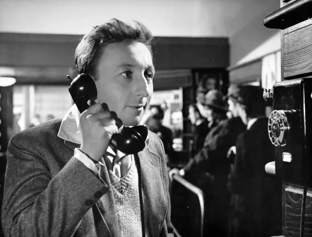 Mężczyzna rozmawia przez telefon, przypominając reżysera