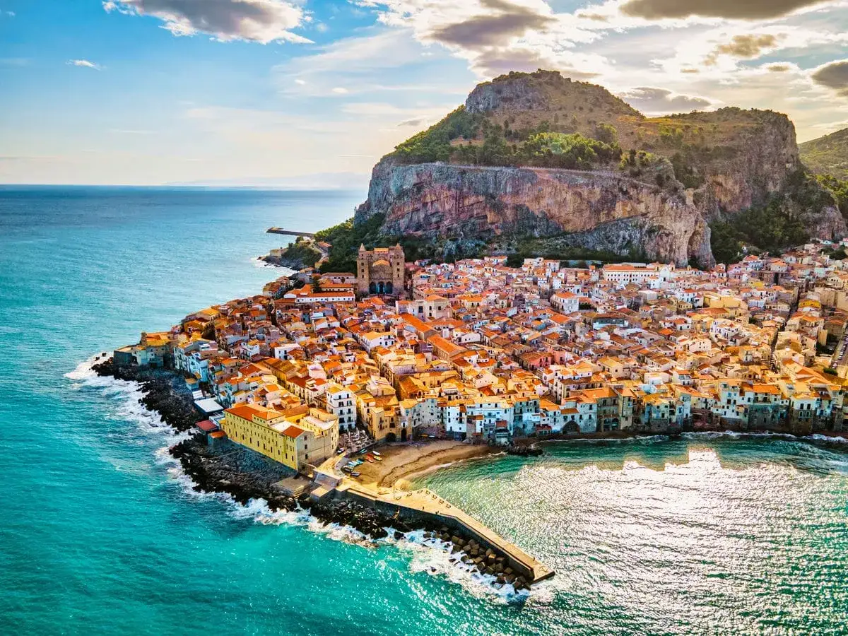 Cefal&ugrave;, Sicilia, vista aerea. Un sogno per un viaggio in moto di 10 giorni, con il mare turchese e la rocca imponente.