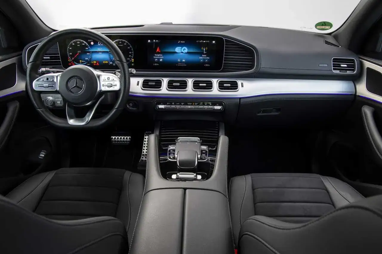 Wnętrze Mercedesa GLE 350 z nowoczesnym kokpitem, dużym ekranem multimedialnym i komfortowymi fotelami.