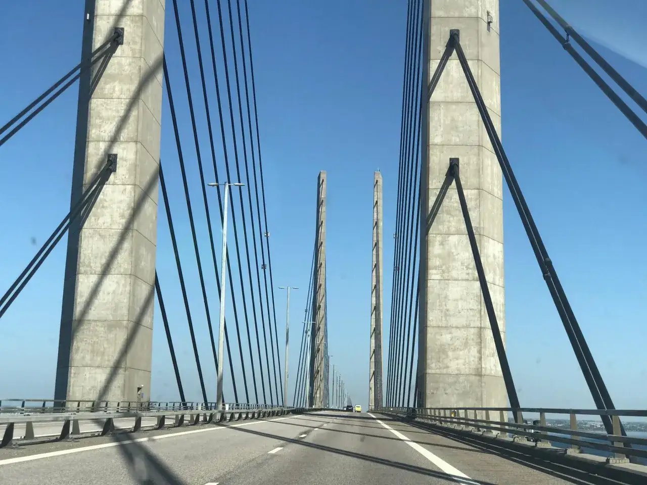 K&ouml;r &ouml;ver &Ouml;resundsbron med nya priser. Betongpelare och vajrar mot en klarbl&aring; himmel.
