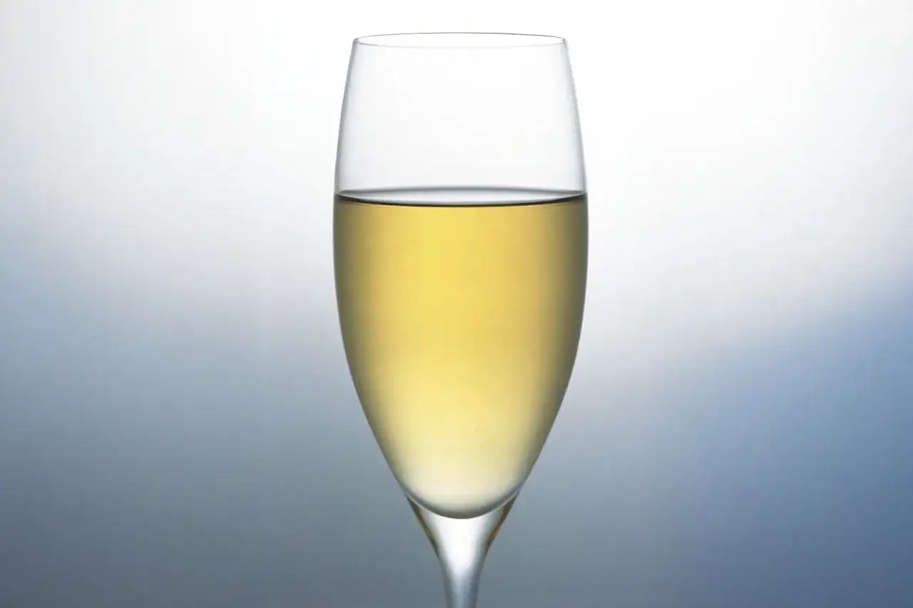 Szklanka wypełniona złotym prosecco, idealna na toast.
