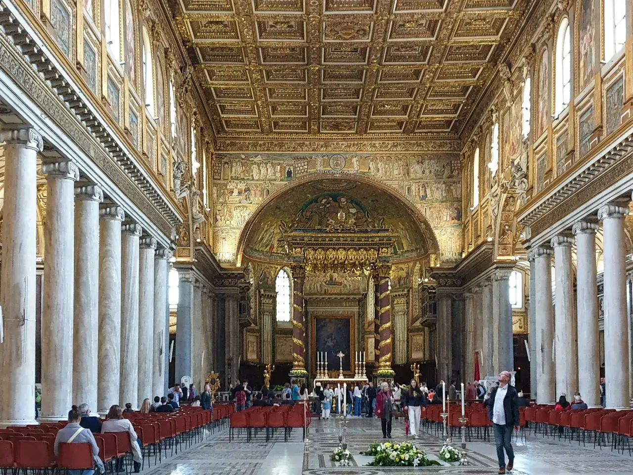 Wnętrze bazyliki Santa Maria Maggiore w Rzymie, z bogato zdobionym złotym sufitem i mozaikami.
