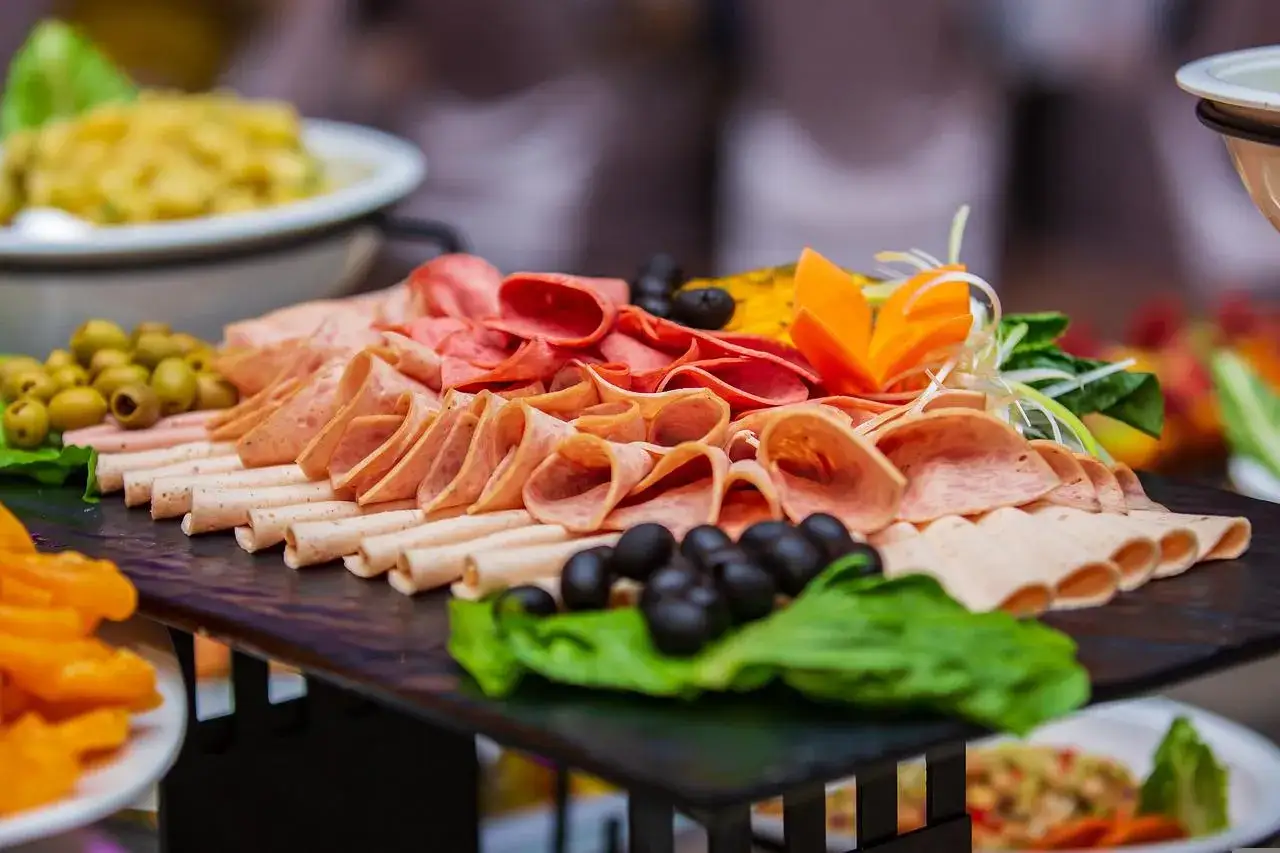 Plateau de charcuterie variée, olives, carottes sculptées. Une belle idée buffet froid pas cher pour 50 personnes, simple et appétissant.