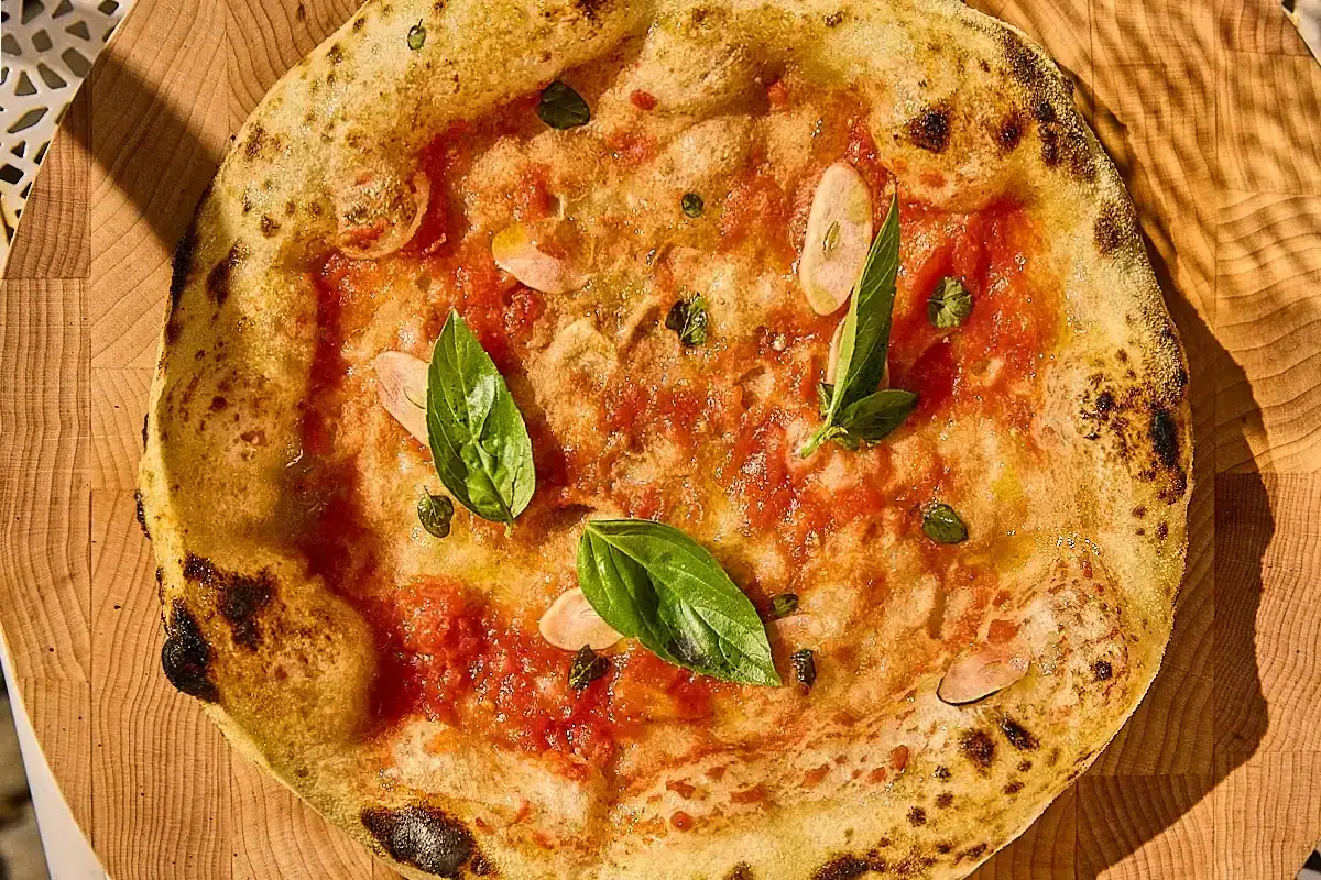 Pizza Marinara mit frischem Basilikum und Knoblauchscheiben. Ein einfaches, aber köstliches Rezept für authentische Pizza.
