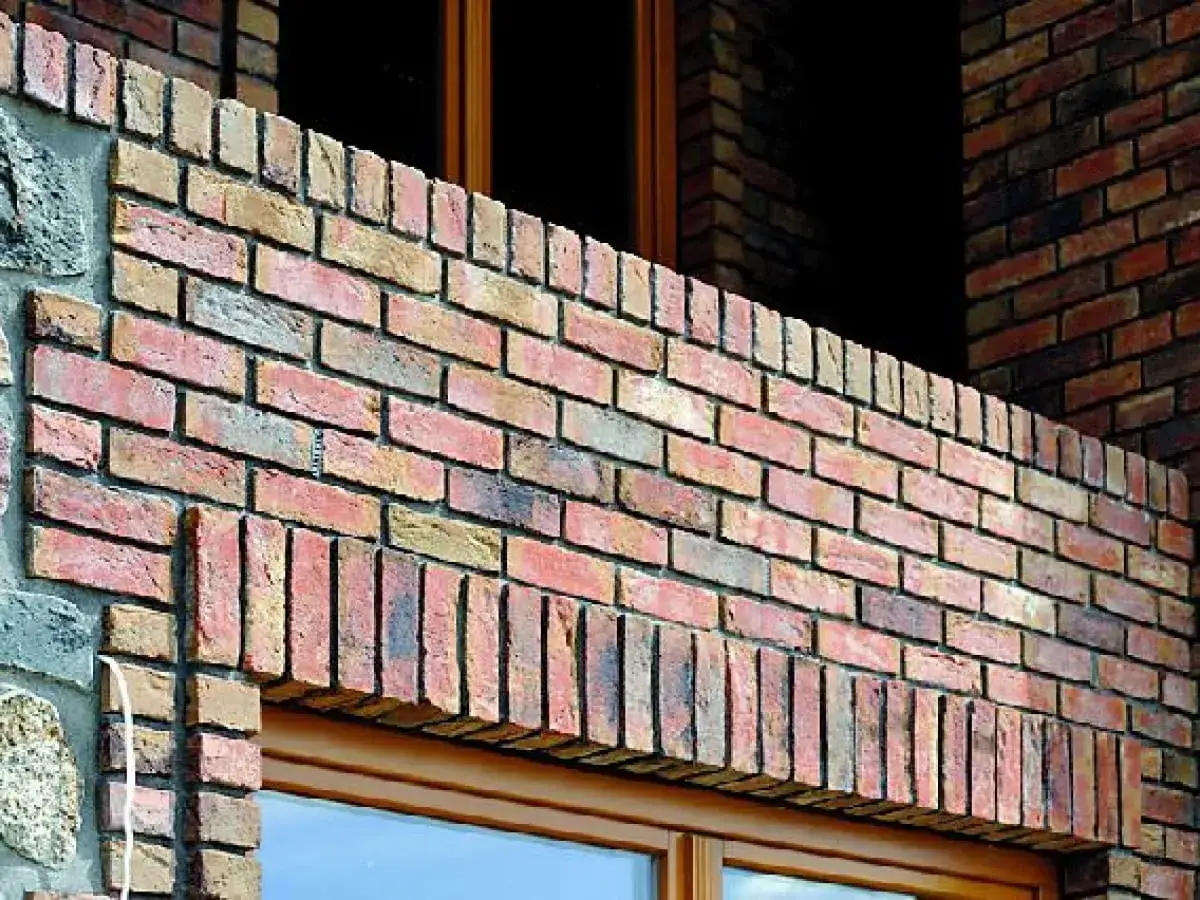 Eleganckie nadproże z cegły nad oknem, tworzące stylowy detal architektoniczny.
