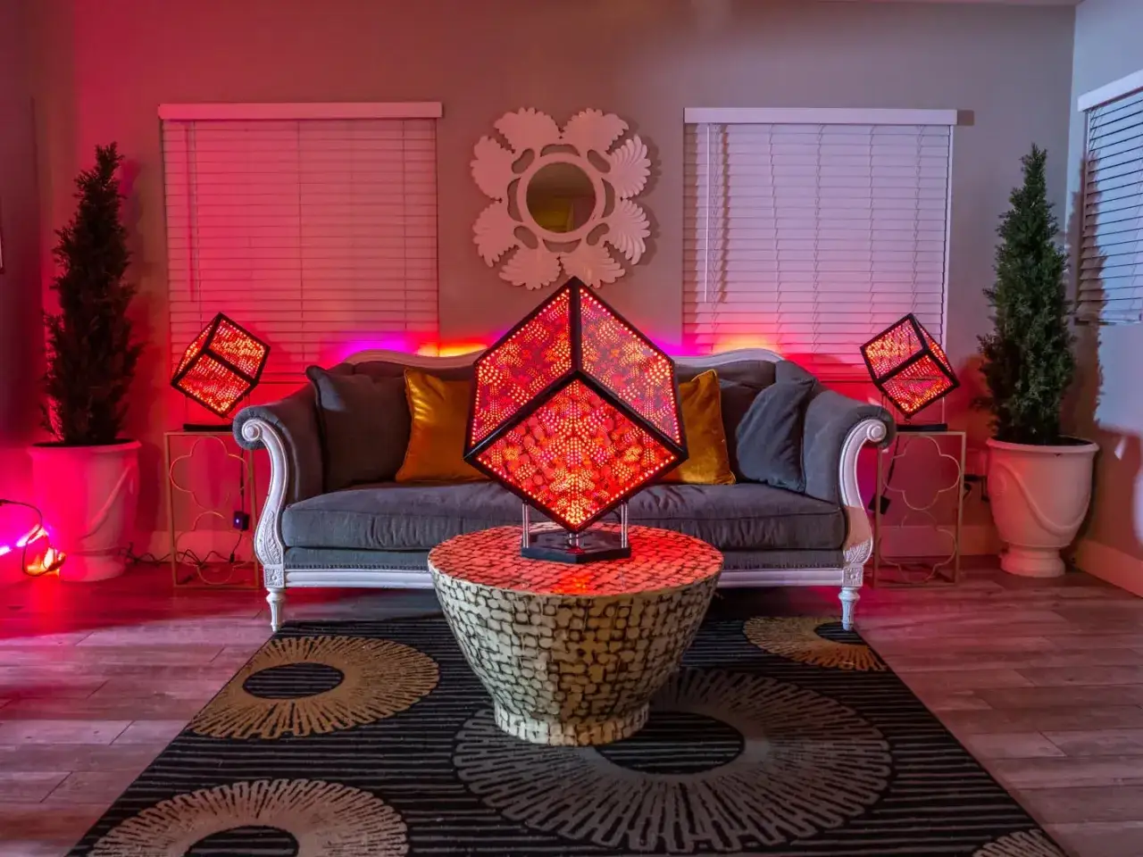 Salon moderne avec canap&eacute; gris, coussins dor&eacute;s et trois lampes cubiques illumin&eacute;es par des LED rouges. Pourquoi LED ? Pour cette ambiance futuriste !