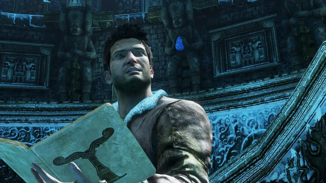 Nathan Drake consulta un antiguo libro, parte de la **Uncharted 2 guia**, en una ruina helada.