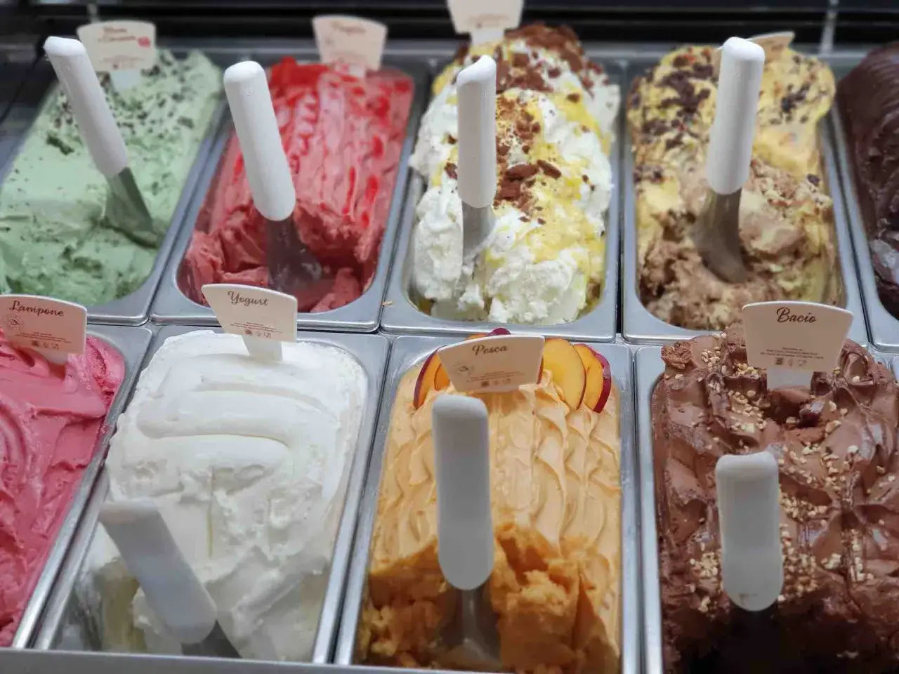 Vielfalt an eis sorten: cremiges Vanilleeis mit Schokost&uuml;ckchen, fruchtiges Pfirsicheis, gr&uuml;nes Minzeis und mehr.
