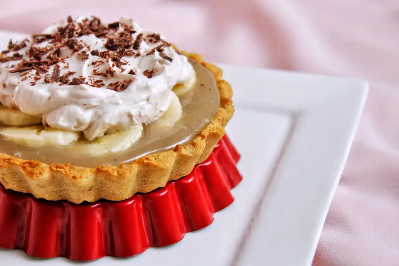 Tartelette banoffee traditionnelle : pâte sablée, bananes, caramel, crème fouettée et copeaux de chocolat. Un délice !