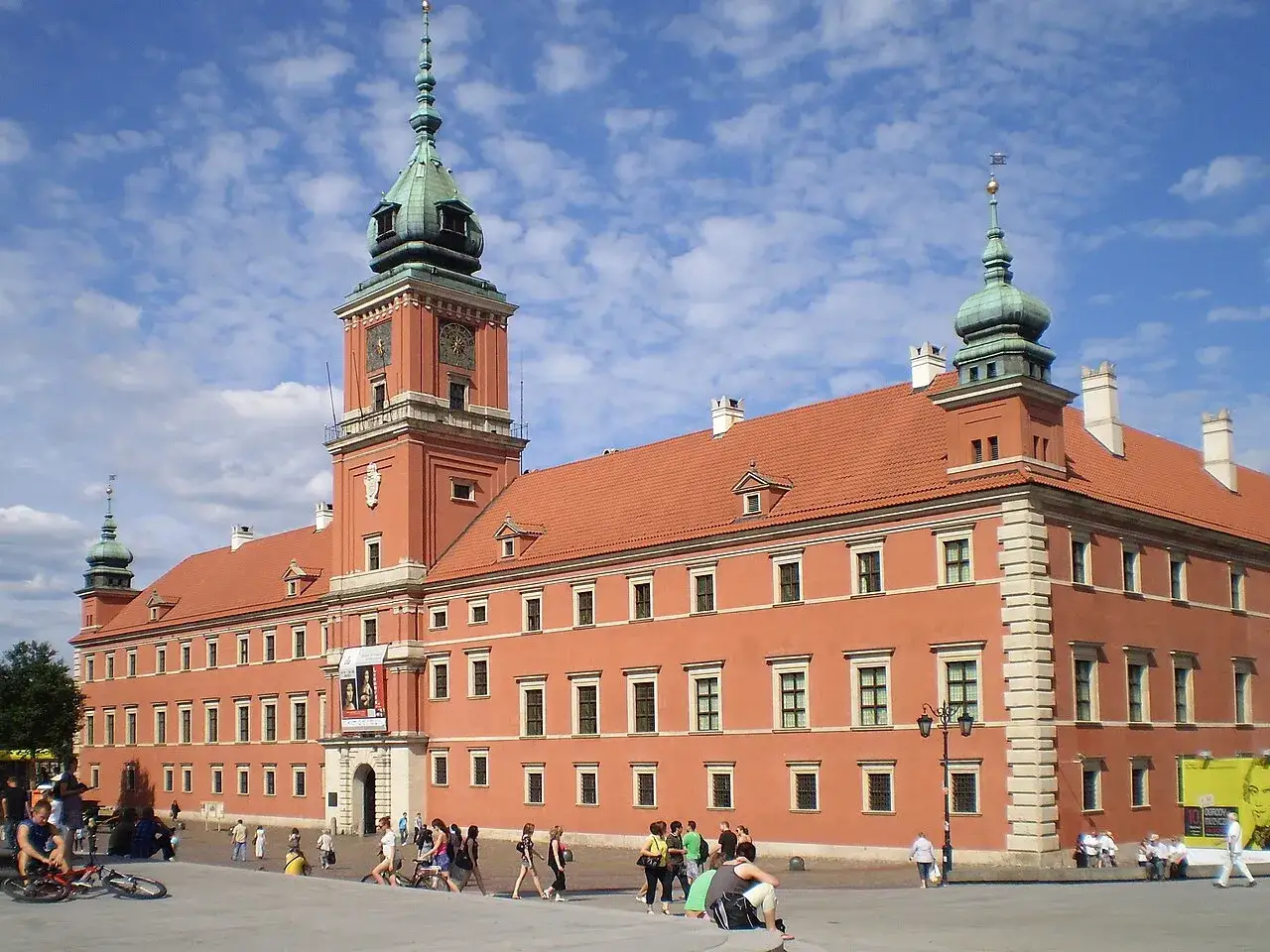 Zamek Królewski w Warszawie, inspiracja dla kultury baroku, z charakterystyczną wieżą i czerwonymi dachami.