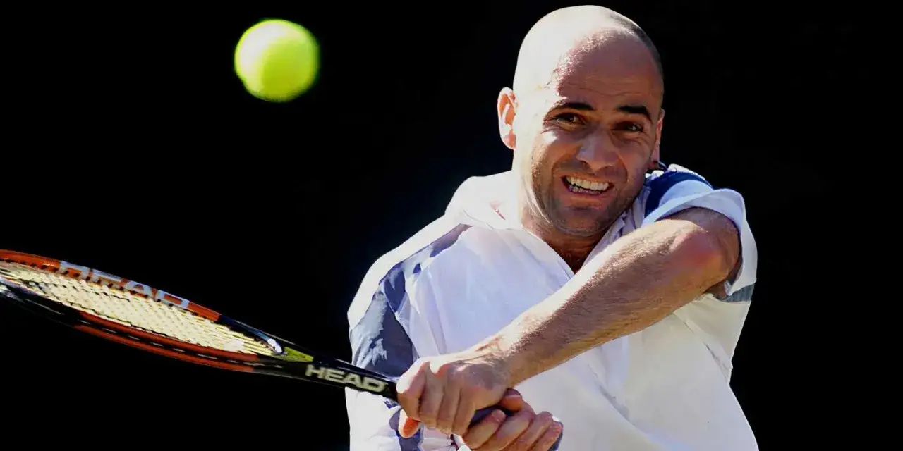Andre Agassi, jeden z najlepsi tenisiści wszechczasów, uderza piłkę rakietą.