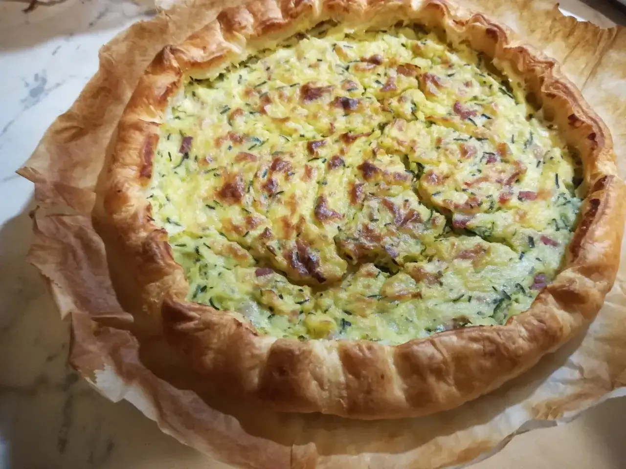Torta salata zucchine e patate dorata e invitante, con crosta sfogliata e ripieno cremoso.