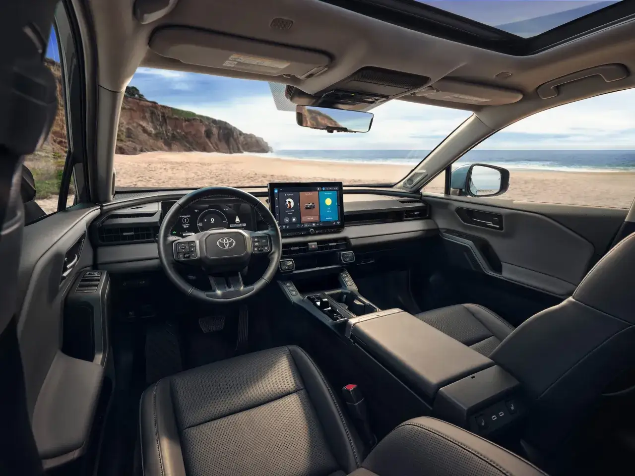 Wnętrze nowoczesnego **toyota rav** z widokiem na plażę i ocean. Skórzana tapicerka, duży ekran multimedialny i panoramiczny dach.